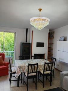 a dining room with a table and chairs and a chandelier at Apartamentos Escorpion Tossa de Mar in Tossa de Mar