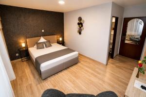 a bedroom with a large bed in a room at Parkhotel Lindenhof - KOSTENLOSE PARKPLÄTZE in Offenbach