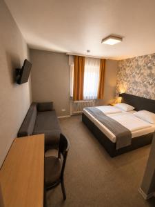 a hotel room with a bed and a table at Parkhotel Lindenhof - KOSTENLOSE PARKPLÄTZE in Offenbach