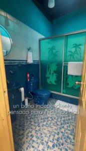 a bathroom with a blue toilet and green walls at Hospedaje Helena in Circasia