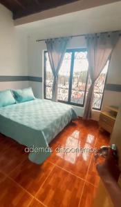 a bedroom with a bed and a large window at Hospedaje Helena in Circasia