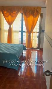 a bedroom with a bed and a window with curtains at Hospedaje Helena in Circasia