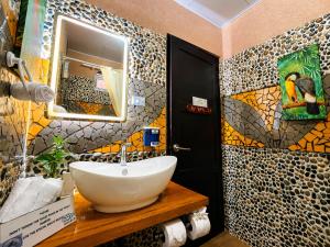a bathroom with a sink and a mosaic wall at Casa Olas in Quepos +29 photos