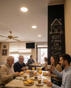 a group of people sitting at a table eating at Hostal Dobe in Benavides