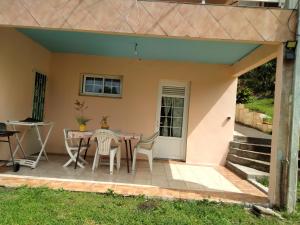 a patio with a table and chairs in front of a house at ecrin de verdure in Fort-de-France +2 photos