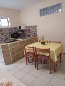 a kitchen with a table and two chairs and a table and a table andheastern at ecrin de verdure in Fort-de-France