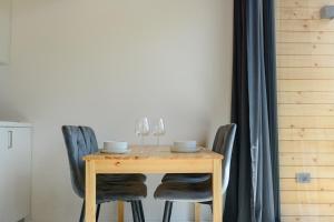 a wooden table with chairs and wine glasses at Domovi Gorjanke - Gorjanka homes in Ajdovščina