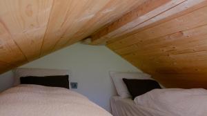 two beds in a small room with wooden ceilings at Domovi Gorjanke - Gorjanka homes in Ajdovščina +6 photos