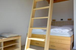 a wooden ladder bunk bed in a bedroom at Domovi Gorjanke - Gorjanka homes in Ajdovščina