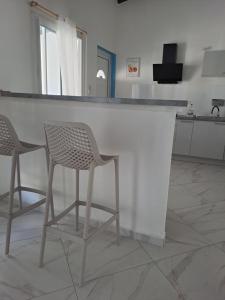 two chairs sitting at a bar in a kitchen at La Casamarie in Saint-Louis