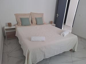 a white bed with two pillows on top of it at La Casamarie in Saint-Louis