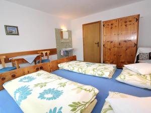 a bedroom with two beds and a wooden door at Veronika in Fulpmes