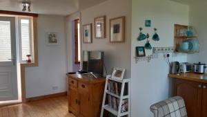 a kitchen with a refrigerator and a wooden cabinet at Jack's place in Balnakeil +20 photos