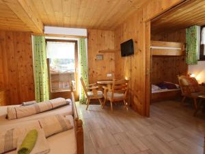 a bedroom with a bed and a table and chairs at Bergheimat L in Huben