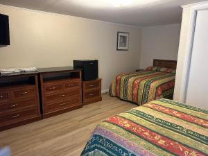 a hotel room with two beds and a flat screen tv at Nitey Nite Motel in South Windsor +4 photos