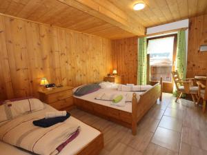 a bedroom with two beds in a wooden cabin at Bergheimat S in Huben