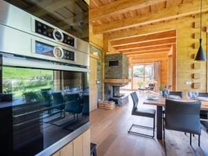 a kitchen and dining room with a fireplace and a dining table at Holzchalet Tauplitz in Tauplitz