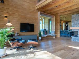 a living room with a fireplace and a flat screen tv at Holzchalet Tauplitz in Tauplitz