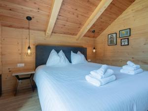 a bedroom with a white bed with towels on it at Holzchalet Tauplitz in Tauplitz +49 photos