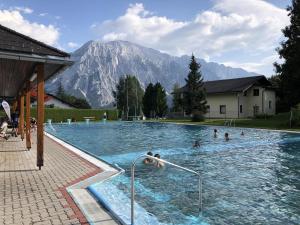 a group of people swimming in a swimming pool at Holzchalet Tauplitz in Tauplitz