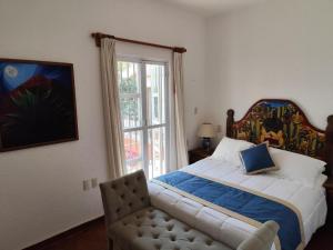 a bedroom with a bed and a chair and a window at Casa de las Conchas Cuernavaca in Cuernavaca +111 photos