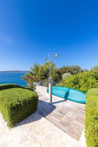 a swimming pool with a light pole and the ocean at Apartment Zavala 553d in Jelsa