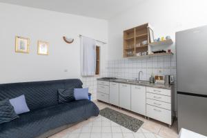 a living room with a couch and a kitchen at Apartment Zavala 553d in Jelsa