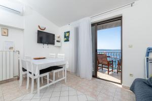a living room with a white table and a balcony at Apartment Zavala 553d in Jelsa