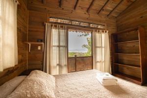 a bedroom with a bed and a large window at Blue Dream Kite Boarding Resort Costa Rica in Puerto Soley
