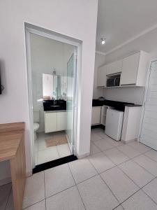 a kitchen with white cabinets and a glass door at Spazio Italian Lofts in Paulínia +7 photos