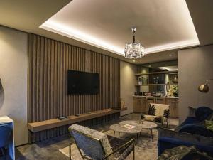 a living room with a television on a wall at Vivari Hotel and Spa by Mantis in Johannesburg