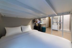 a bed with white pillows in a room at lazy tiger hotel in Seoul