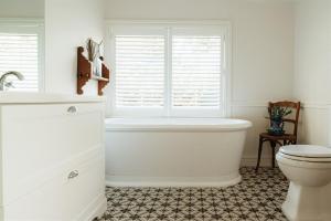 a bathroom with a tub and a toilet and a window at Aldourie Lodge - Lake Tekapo in Lake Tekapo +25 photos