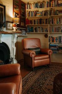 a living room with a leather chair and a fireplace at Aldourie Lodge - Lake Tekapo in Lake Tekapo