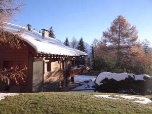 une cabane en rondins avec de la neige sur le toit dans l'établissement Etoile du Sud 108, à Verbier