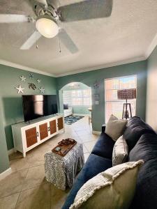 a living room with a blue couch and a tv at Waves, Sun & Relaxation Retreat in Clearwater Beach