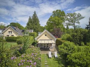 a house with a garden with benches and flowers at Wellnesshuisje Kalheupink in Oldenzaal