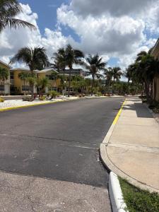 an empty street with palm trees on the side of the road at Waves, Sun & Relaxation Retreat in Clearwater Beach