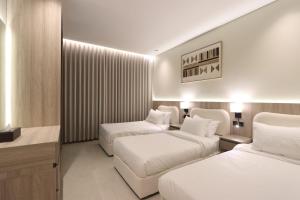 a hotel room with two beds and a desk at دار المصطفى in Al-Salam