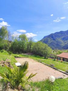 a dirt road in a field with a house and mountains at Teranga in Artigues +6 photos