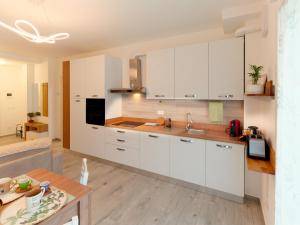 a kitchen with white cabinets and a wooden table at Assisi valley - Modern Apartment with Covered Parking in Bastia Umbra