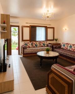 a living room with couches and a table at Plage al amin eden in Fnidek