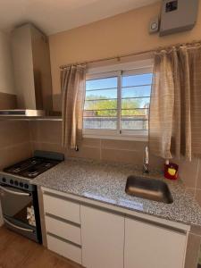a small kitchen with a sink and a window at Lihuel 1 AG in Alta Gracia