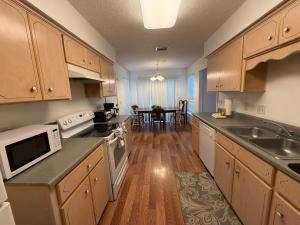 a kitchen with wooden cabinets and a dining room at House 210 Brunswick in Brunswick