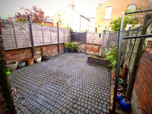 a courtyard with potted plants and a fence at Central Reading Guest House in Reading