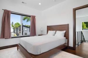 a bedroom with a large bed and a large window at Beautiful new home in Sanders Beach! in Coeur d'Alene