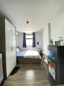 a small bedroom with a bed and a refrigerator at Thien Khanh Hotel for rent in Danang