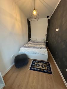 a bedroom with a bed and a black chair at Vendégház Alsóörs in Alsóörs