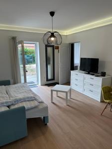 a living room with a bed and a tv at Vendégház Alsóörs in Alsóörs
