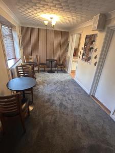 a living room with a table and chairs in a room at Hawkins Guesthouse in Milton